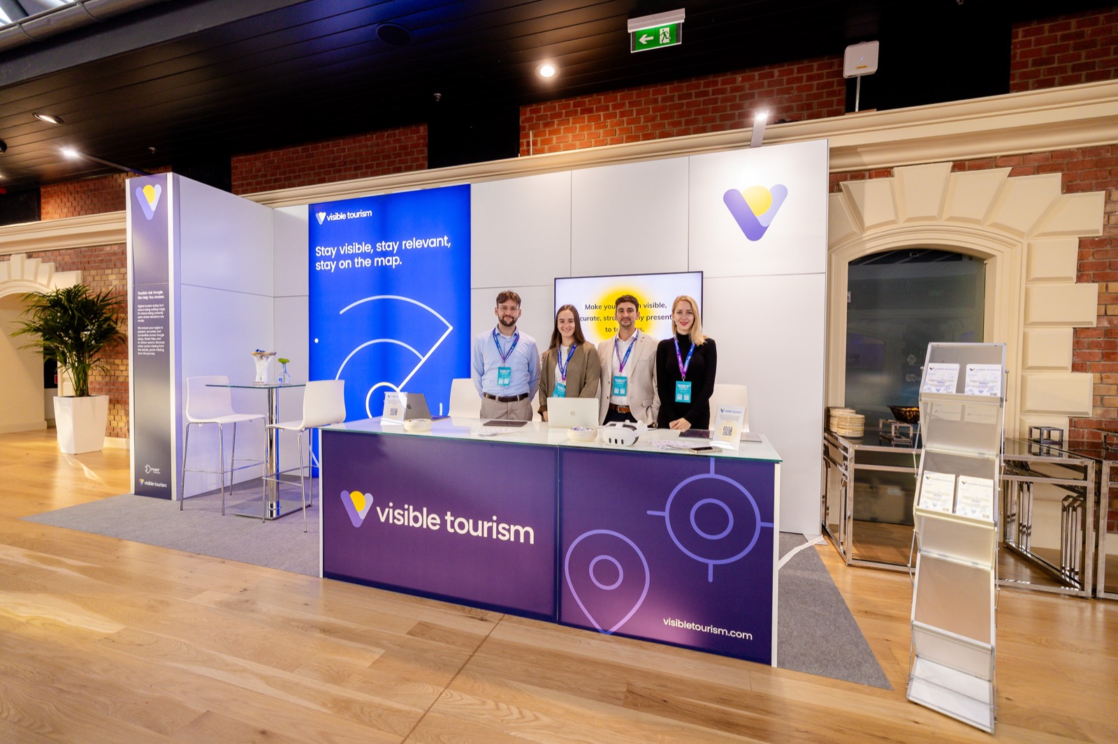 The Visible Tourism stand at Tourism Summit 2025 (Bálna, Budapest) – “Stay visible, stay relevant, stay on the map.” | The Visible Tourism team at the stand at Tourism Summit 2025 | The Visible Tourism team at the Tourism Summit 2025 stand | A professional conversation at the Visible Tourism stand at Tourism Summit 2025 | Adam Schmutz talking with a visitor at the Visible Tourism stand at Tourism Summit 2025